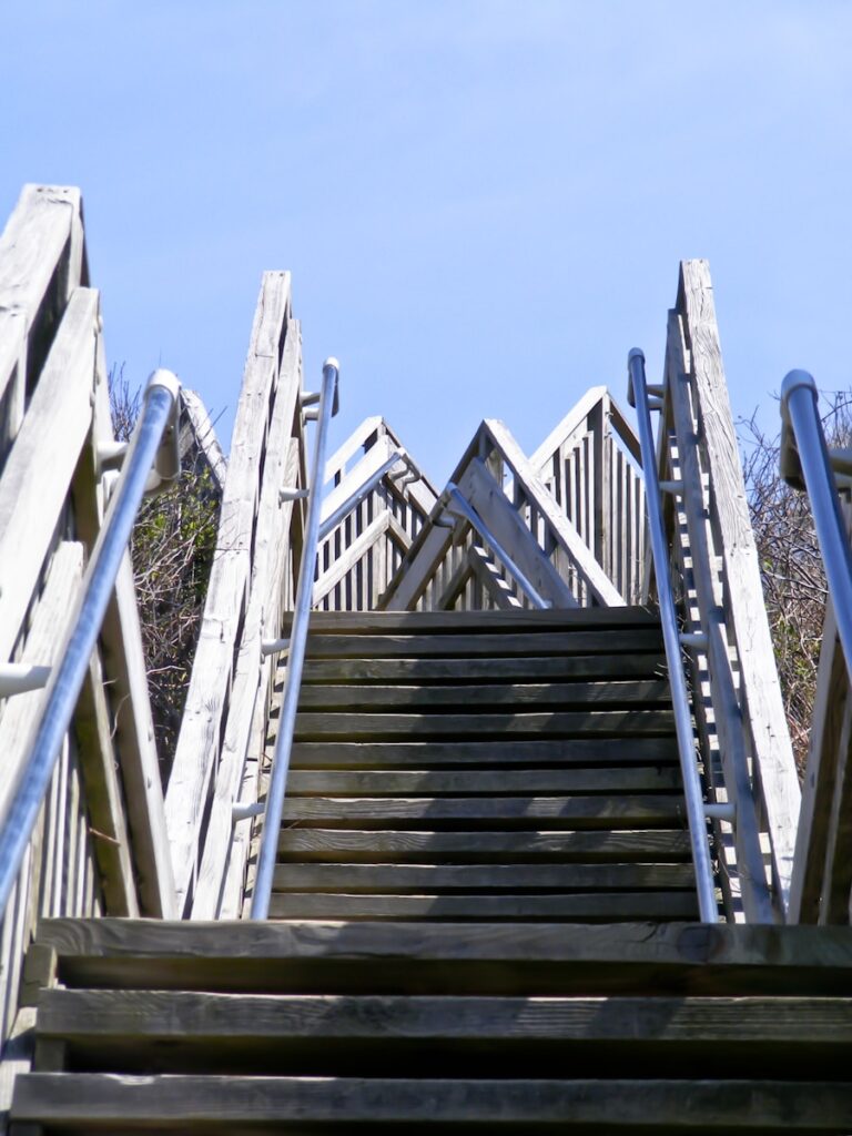 A set of stairs leading up to the top of a hill to show team climbing