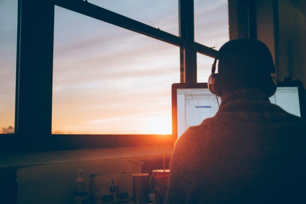 man sitting facing monitor to concentrate on tasks