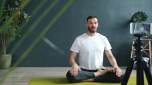 Man meditating on yoga mat to build mental fitness