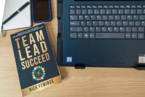 a laptop and a book with lead team on it