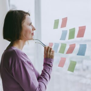 a woman looking out a window with sticky notes on it about leadership problems 